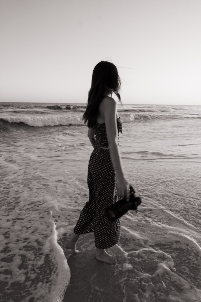 Wedding photographer twirling in the water at Pensacola Beach.