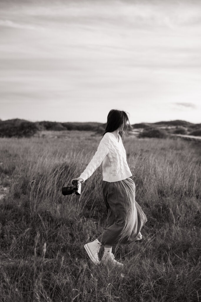 Pensacola wedding photographer spinning in a field at Fort Pickens on the Florida Panhandle.