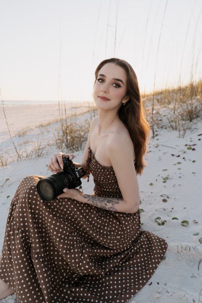 Pensacola wedding photographer sitting in the sand at Pensacola Beach.