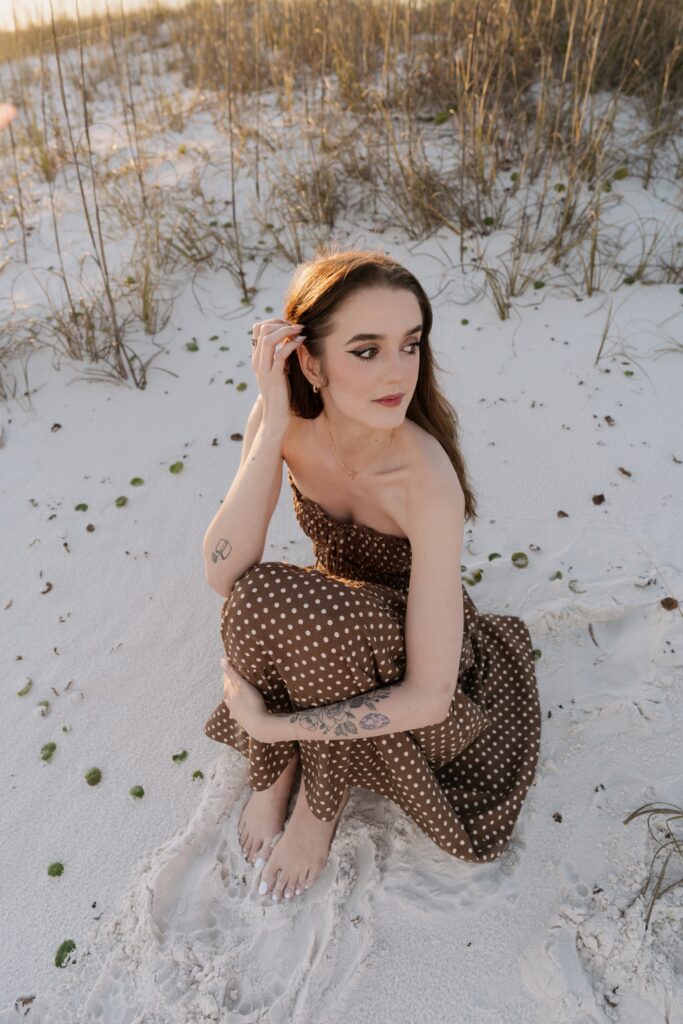 Wedding photographer sitting in the sand on Pensacola Beach.
